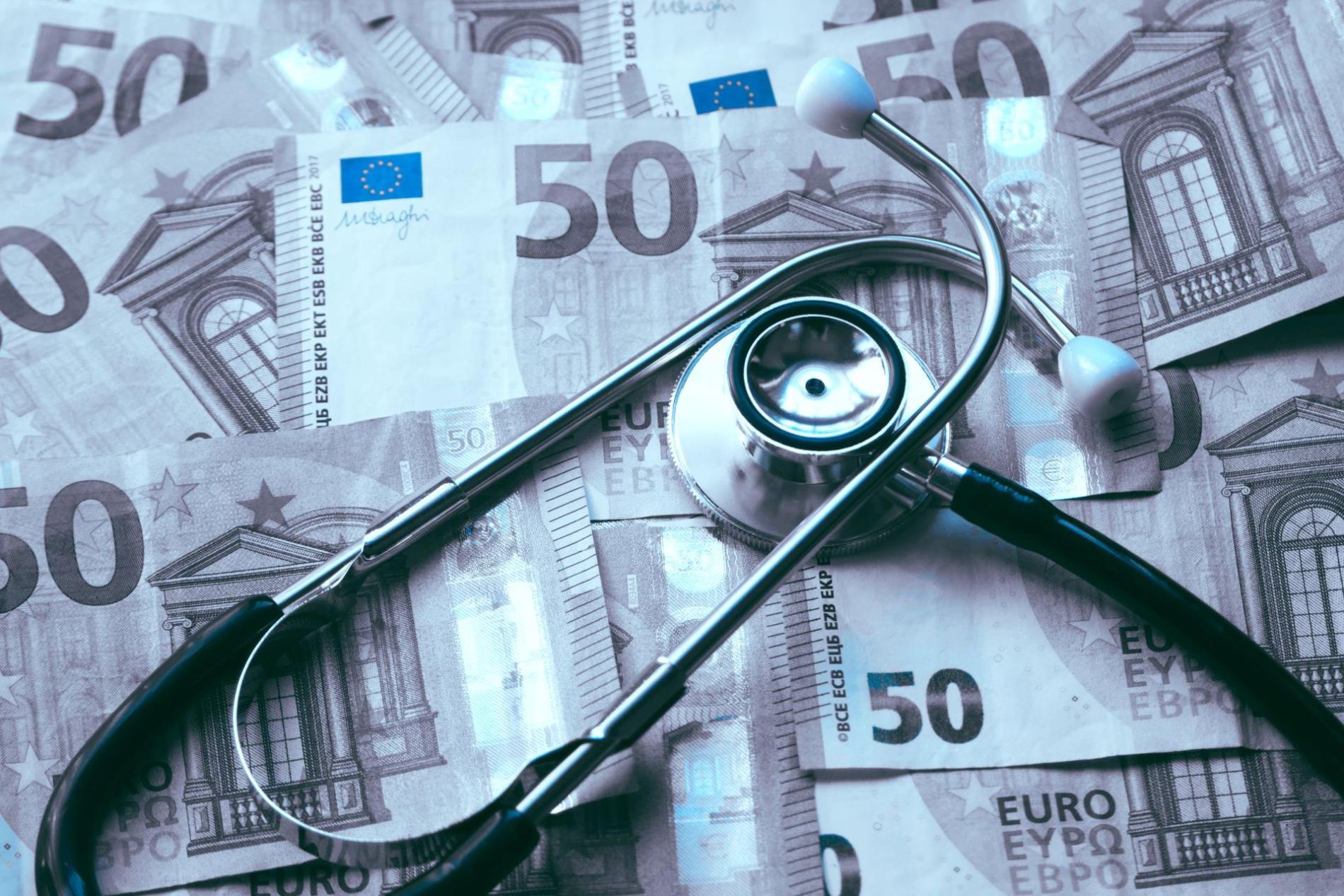 Stéthoscope posé sur des billets de 50 euros, symbolisant le financement des soins de santé, les coûts médicaux ou le budget de la santé Stéthoscope posé sur des billets de 50 euros, symbolisant le financement des soins de santé, les coûts médicaux ou le budget de la santé