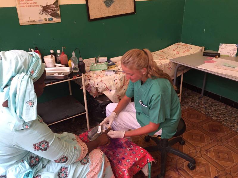 Roxanne, jeune étudiante en mission au Sénégal, prodigue des soins à une patiente / Roxanne, een jonge studente op missie in Senegal, verzorgt een patiënt