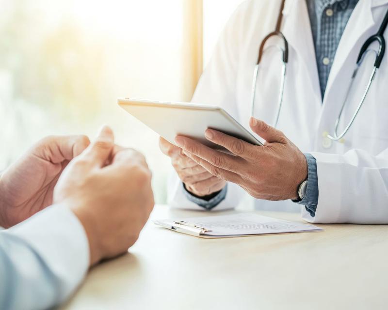 Médecin consultant en soins de santé avec tablette numérique dans un bureau ensoleillé