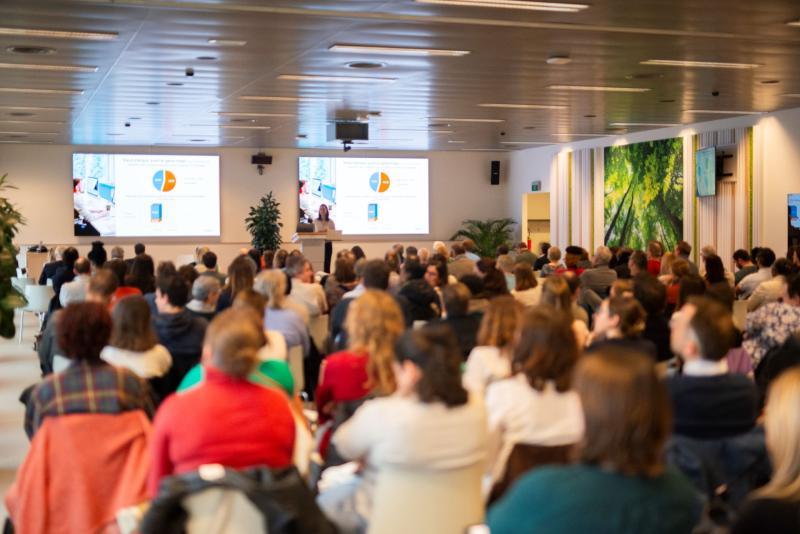 Oratrice présente son sujet et projette des slides face à une salle comble